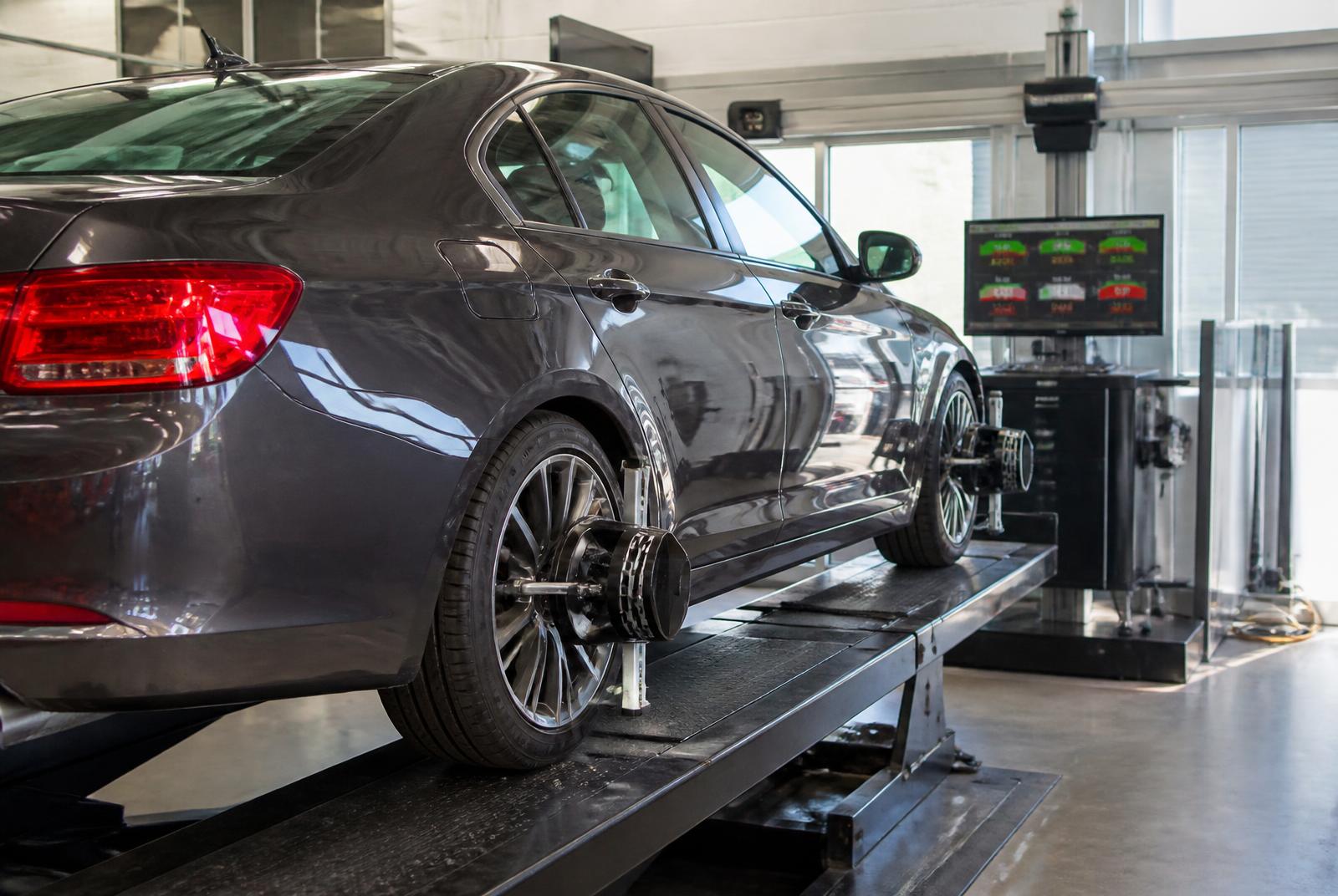 Sedan on a wheel alignment rack with alignment sensors clamped to the wheels